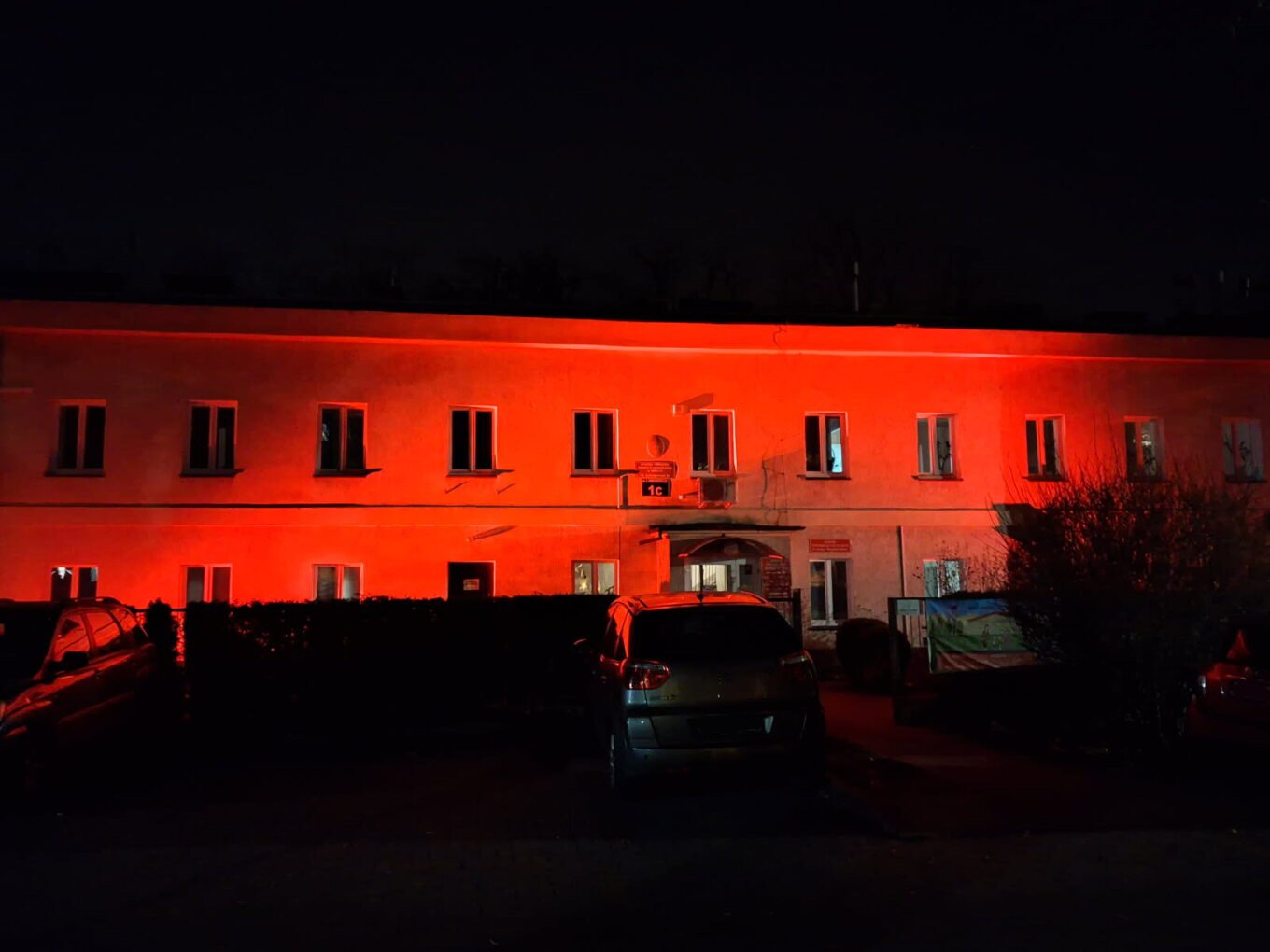 Zdjęcie oświetlonego na czerwono budynku MOPS